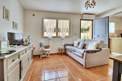 a living room with a couch and a tv at Appartement T2 Prunello By Intendance Excellency in Porto-Vecchio