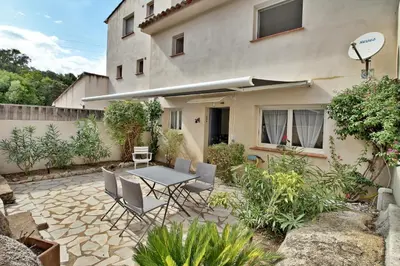 a patio with a table and chairs in front of a building at Appartement T2 Prunello By Intendance Excellency in Porto-Vecchio