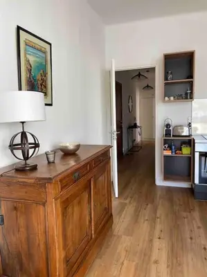 a living room with a table with a lamp on it at Appartement neuf, 2 chambres, climatisé, route des Sanguinaires in Ajaccio