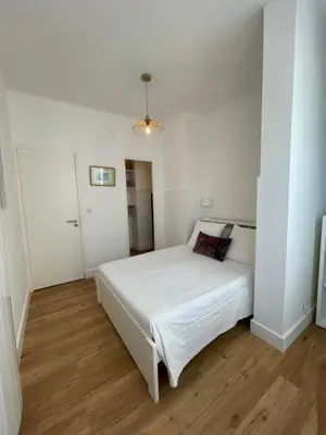 a bedroom with a white bed in a room at Appartement neuf, 2 chambres, climatisé, route des Sanguinaires in Ajaccio