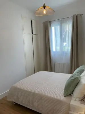 a bedroom with a white bed with a window at Appartement neuf, 2 chambres, climatisé, route des Sanguinaires in Ajaccio