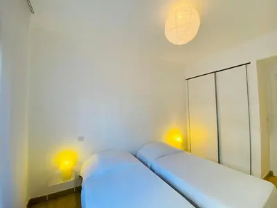 a white room with a bed and two lights at Les Jardins de Quatrina 2 chambres vue mer in Propriano