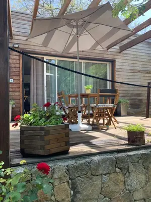 a patio with an umbrella and a table and chairs at Caselena , un havre de paix en Balagne in Ville-di-Paraso