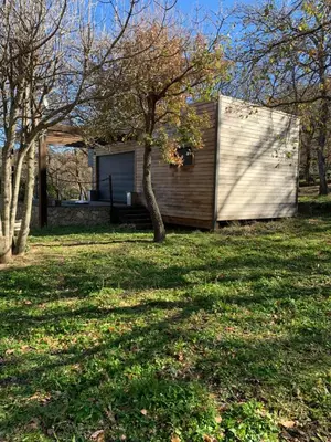 a small house in a yard with a tree at Caselena , un havre de paix en Balagne in Ville-di-Paraso