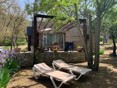 a couple of chairs sitting in front of a cabin at Caselena , un havre de paix en Balagne in Ville-di-Paraso