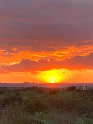 a sunset in the desert with the sun setting at Caselena , un havre de paix en Balagne in Ville-di-Paraso