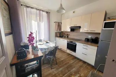 a kitchen with a small table and a kitchen with white cabinets at Casa Torra in Omessa