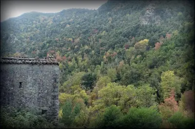 a view of a mountain with a tower and trees at Casa Torra in Omessa