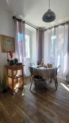 a living room with a table and chairs and windows at Casa Torra in Omessa