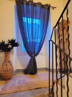 a blue curtain in a room with a window at Casa Torra in Omessa