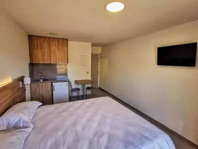 a bedroom with a large bed and a kitchen at Ustaria in Peri