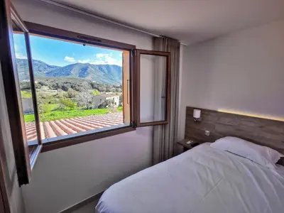 a bedroom with a bed and a window with a view at Ustaria in Peri