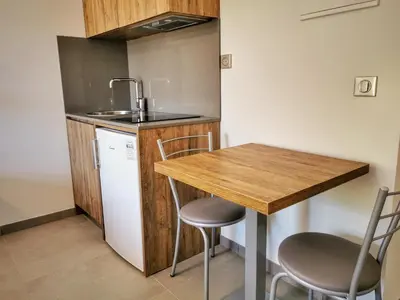 a small kitchen with a wooden table and chairs at Ustaria in Peri