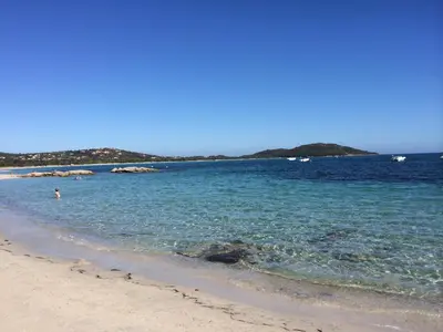 a beach with a person swimming in the water at Liflosa in Lecci