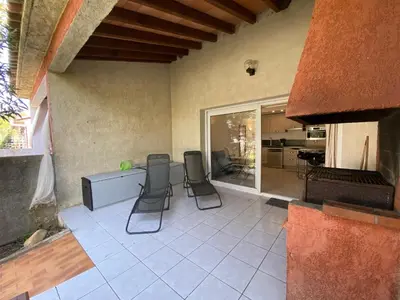 a patio with chairs and a table and a kitchen at Liflosa in Lecci