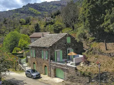 a stone house with a car parked in front of it at U Castellu di A Sulana in Casabianca