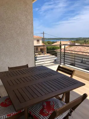 a wooden table and chairs on a balcony at Mare e Monti in Aléria