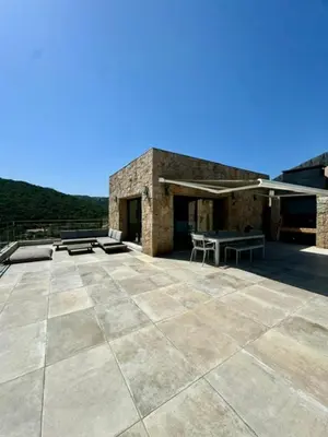 a building with a patio with a table and chairs at Somptueuse villa d’architecte avec vue mer in Belvédère