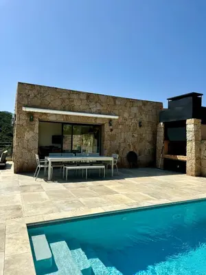 a patio with a table and a swimming pool at Somptueuse villa d’architecte avec vue mer in Belvédère