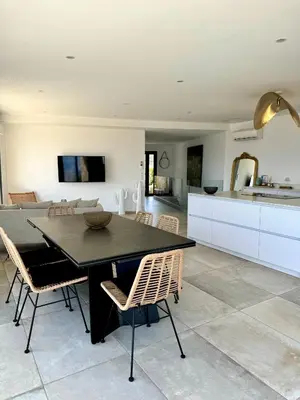 a kitchen and dining room with a table and chairs at Somptueuse villa d’architecte avec vue mer in Belvédère