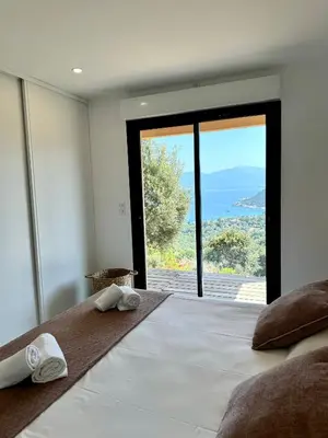 a bedroom with a large bed with a view of the ocean at Somptueuse villa d’architecte avec vue mer in Belvédère
