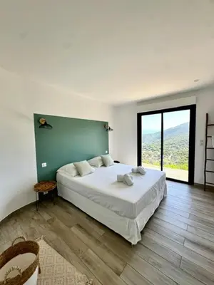a bedroom with a large bed and a large window at Somptueuse villa d’architecte avec vue mer in Belvédère
