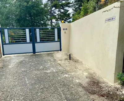 a blue gate in front of a wall at un ecrin de verdure face à la mer in Isolaccio-di-Fiumorbo