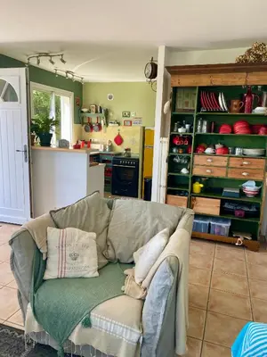 a living room with a couch and a kitchen at un ecrin de verdure face à la mer in Isolaccio-di-Fiumorbo