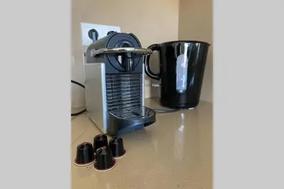 a coffee maker sitting on a counter next to a cup at Salina Bay Porto Vecchio in Porto-Vecchio