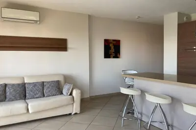 a living room with a couch and a bar at Salina Bay Porto Vecchio in Porto-Vecchio