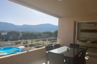 a room with a balcony with a table and a view at Salina Bay Porto Vecchio in Porto-Vecchio