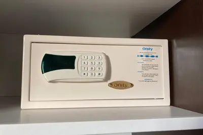 a microwave with a digital clock on top of a shelf at Salina Bay Porto Vecchio in Porto-Vecchio