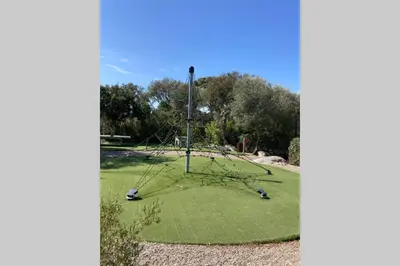 a golf course with a tree in the grass at Salina Bay Porto Vecchio in Porto-Vecchio
