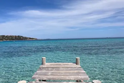 a wooden dock in the middle of the ocean at Salina Bay Porto Vecchio in Porto-Vecchio