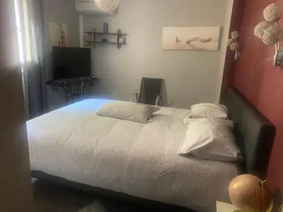 a bedroom with a bed with white sheets and a television at Duplex F4-2 balcons face a la mer in Ajaccio