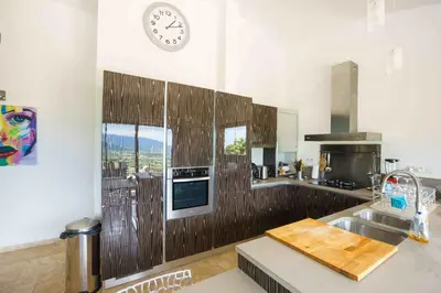 a kitchen with a sink and a clock on the wall at A Muredda in Figari