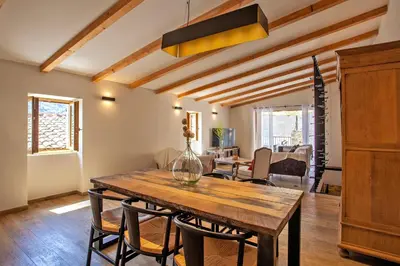 a dining room with a wooden table and chairs at Maison de Charme-A STALLA- Entre Mer et Montagne in Muro