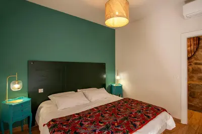 a bedroom with a large bed with a green wall at Maison de Charme-A STALLA- Entre Mer et Montagne in Muro