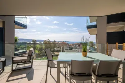 a dining room with a table and chairs on a balcony at Agosta Sea View in Porticcio