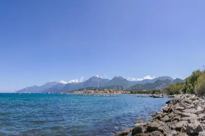 a body of water with mountains in the background at gite au paradis, parc animalier in Olmeta-di-Tuda