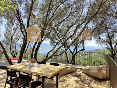 a wooden table and chairs on a patio at Résidence Licciola in Propriano