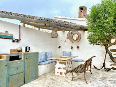an outdoor kitchen with a table and a table sidx sidx sidx at La Chambre du Phare à Porto-Vecchio, unique ! in Porto-Vecchio