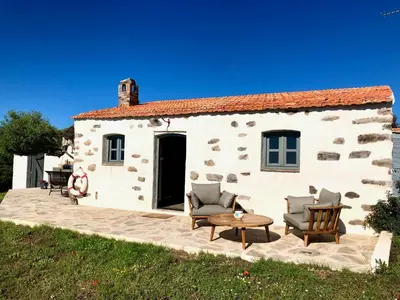 a house with two chairs and a table in front of it at La Chambre du Phare à Porto-Vecchio, unique ! in Porto-Vecchio