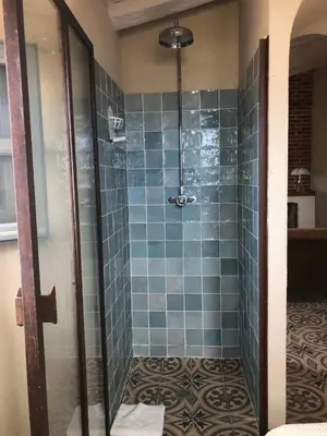 a bathroom with a shower with blue tile at La Chambre du Phare à Porto-Vecchio, unique ! in Porto-Vecchio
