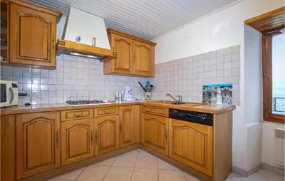 a kitchen with wooden cabinets and a sink at Amazing Home In Morosaglia With Wifi in Morosaglia