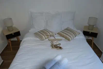 a bed with a pair of gloves on top of it at Mini villa T3 climatisée, vue mer, cosy & moderne in Olmeto