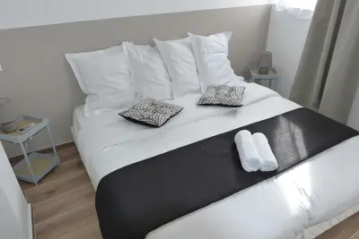 a white bed with two pillows on top of it at Mini villa T3 climatisée, vue mer, cosy & moderne in Olmeto