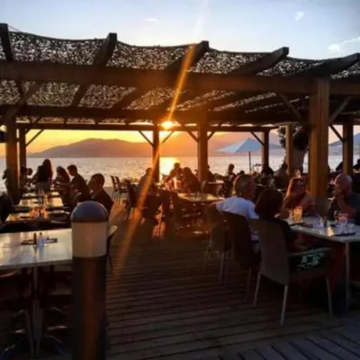 a group of people sitting at tables in a restaurant at Les Rivages de Stagnola Appartement T3 vue mer et montagne plage 200m climatisé in Pietrosella