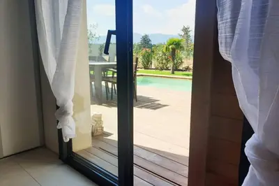 a glass door with a view of a pool at Villa 5***** piscine proche de la plage Cala Rossa in Lecci