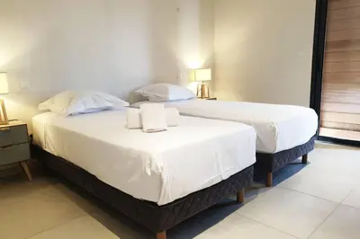 two beds in a hotel room with towels on them at Villa 5***** piscine proche de la plage Cala Rossa in Lecci